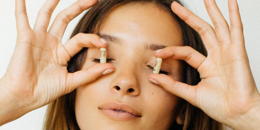 Woman holding menopause supplements in front of her eyes