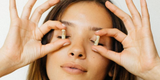 Woman holding menopause supplements in front of her eyes