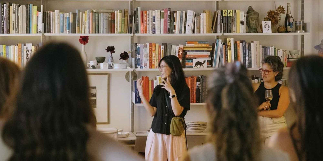 A group of women gathered against a wall of books