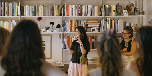 A group of women gathered against a wall of books
