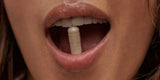 A woman with a menopause supplement in between her teeth