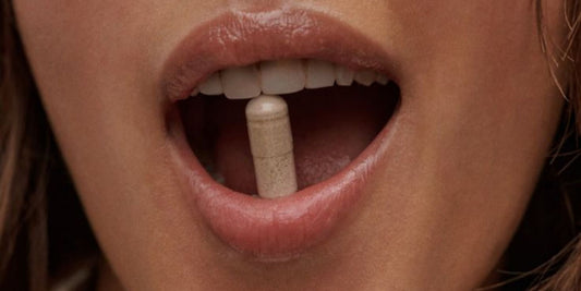 A woman with a menopause supplement in between her teeth
