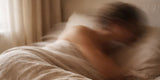 A blurred woman lying in bed