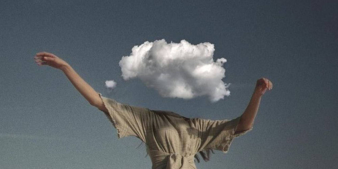 a person with their arms stretched out and with a head made from clouds