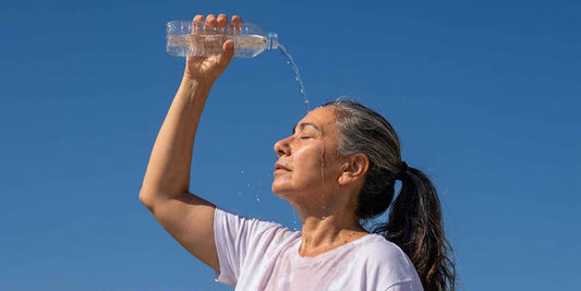 A woman outside and pouring water over her head