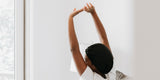 A woman with her arms stretched out as she wakes up