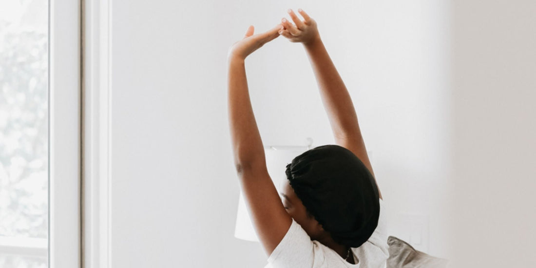 A woman with her arms stretched out as she wakes up