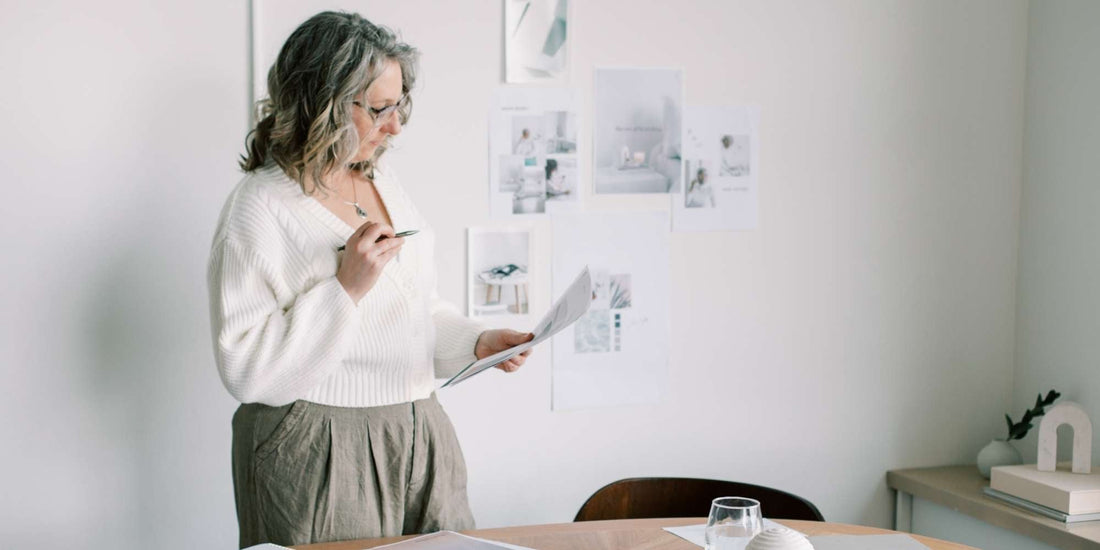 A woman holding a pen and looking at a piece of paper